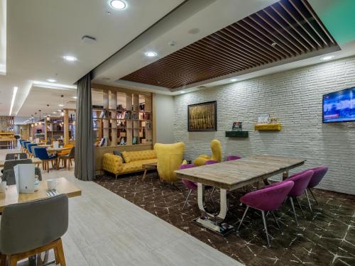 a library with a table and chairs and a couch at Holiday Inn Antalya - Lara by IHG in Antalya