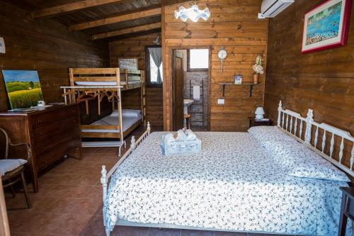 a bedroom with a bed in a wooden cabin at Azienda Agricola Biologica La Cardellina in Tolfa