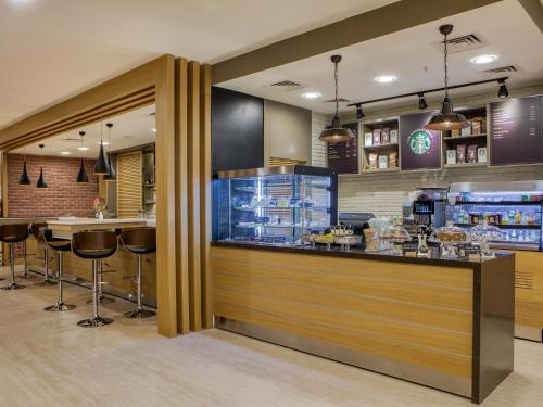 a restaurant with a counter and bar with stools at Holiday Inn Antalya - Lara by IHG in Antalya