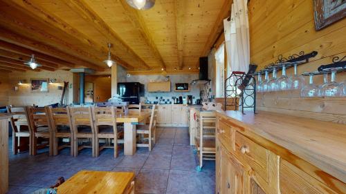 un restaurante con paredes de madera, mesas y sillas en REFLET DES AIGUILLES - Chalet avec Jacuzzi en La Toussuire