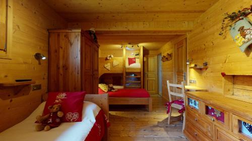 um quarto com uma cama num chalé de madeira em REFLET DES AIGUILLES - Chalet avec Jacuzzi em La Toussuire