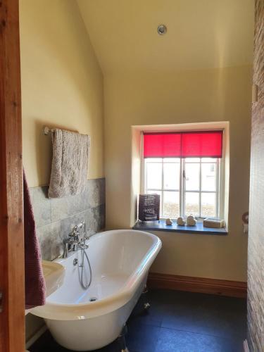 a large bathroom with a tub and a window at Old Printers Ruthin in Ruthin