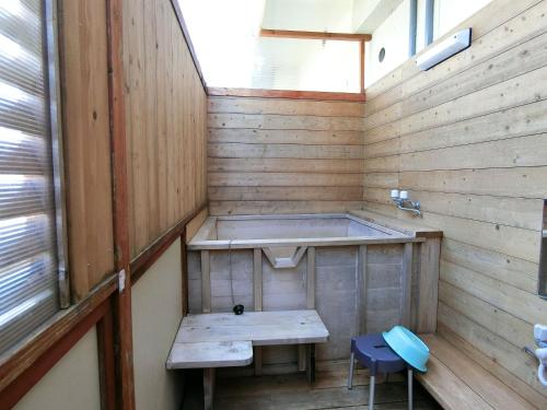 a sauna with a bench and a tub at Yurakuan Miyazaki in Miyazaki