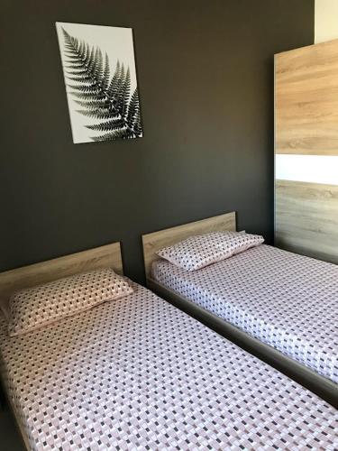- 2 lits installés l'un à côté de l'autre dans une chambre dans l'établissement Luqa Apartment - 5 mins from Airport, à Ħal Luqa