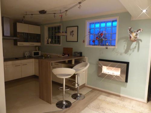 a kitchen with a bar stool and a fireplace at Haus Valder in Niedernsill