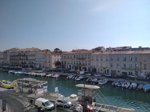 a group of boats parked in a river with buildings at Grand T2 au COEUR DE VILLE avec VUE SUR QUAIS ET MER in Sète