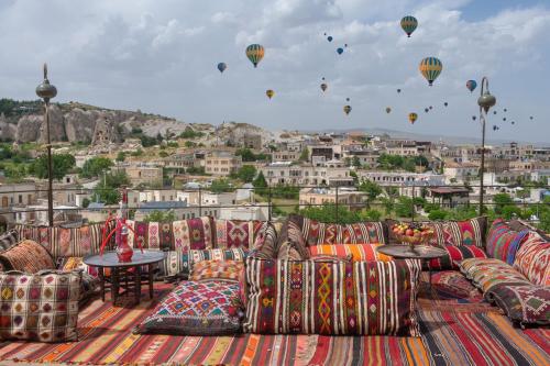 a group of couches sitting on a roof with hot air balloons at Hera Cave Suites in Goreme