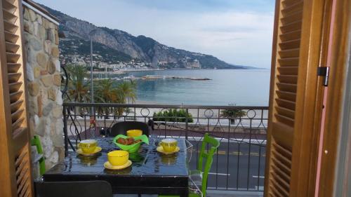 una mesa con fruta en el balcón con vistas al océano en Apartment les Sablettes panoramic sea view, en Menton