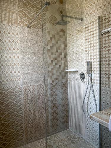a shower with a glass door in a bathroom at Residenza Case Arse in Torre Lapillo