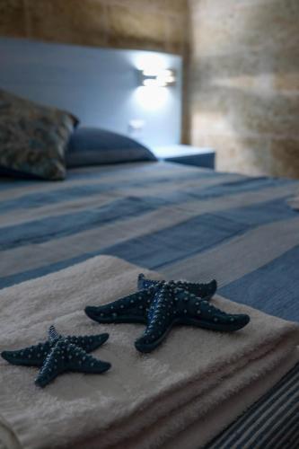two stars on top of a bed at Residenza Case Arse in Torre Lapillo