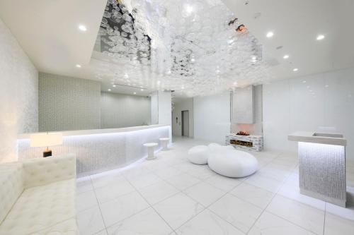 a large white room with a fireplace and a ceiling at Quintessa Hotel Sapporo Susukino in Sapporo