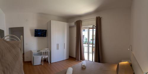 un soggiorno con un letto e una porta scorrevole in vetro di Prestige house a Scalea