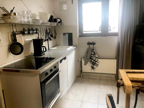 een keuken met een fornuis, een wastafel en een raam bij Rudis Werkstatt in Bremen