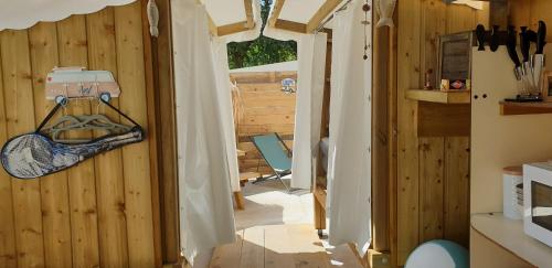 eine offene Tür zu einer Küche mit Holzwänden in der Unterkunft Tente lodge et logement atypique pour 2 à 6 pers aux Mathes La Palmyre in Les Mathes