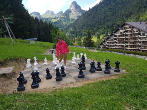 a woman playing chess on a giant chess board at Résidence "Les Crêtes" in Torgon