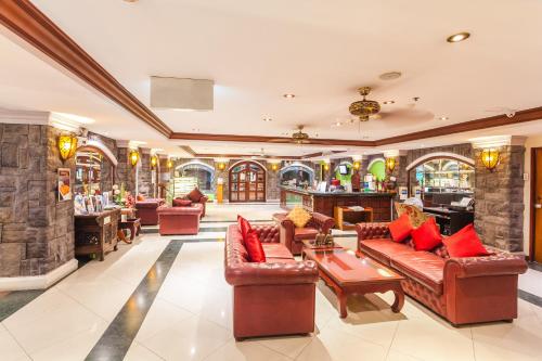 a lobby with leather couches and a bar at Tara Court Hotel in Pattaya South
