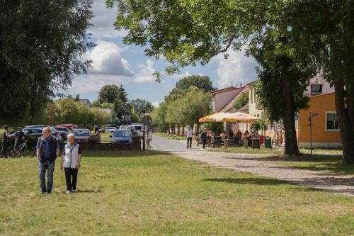 a man and a woman walking in a park at Pension am See in Kremmen