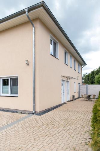 a house with a brick driveway in front of it at Pension am See in Kremmen
