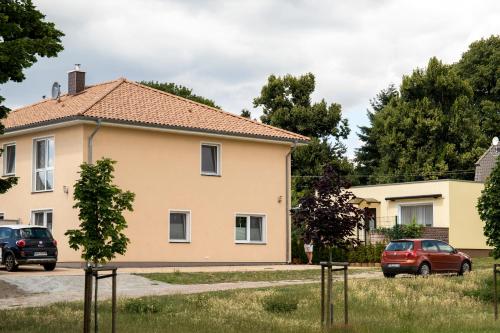 a house with cars parked in front of it at Pension am See in Kremmen