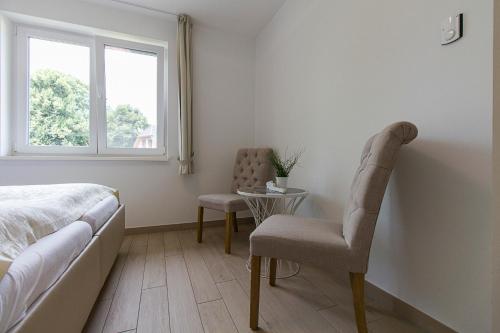 a bedroom with a bed and a chair and a table at Pension am See in Kremmen