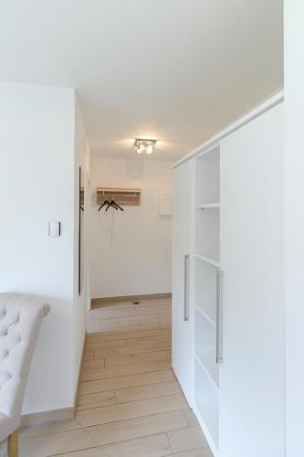 a hallway with white walls and a white closet at Pension am See in Kremmen