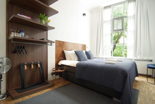 1 dormitorio con cama y ventana en Stuart Luxury Rooms en Ámsterdam