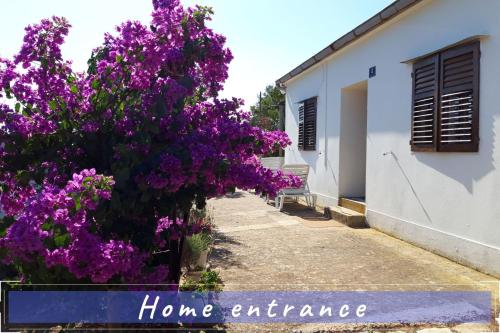 a house with purple flowers and a sign that says home entrance at Near the sea vacation home Parja in Vis
