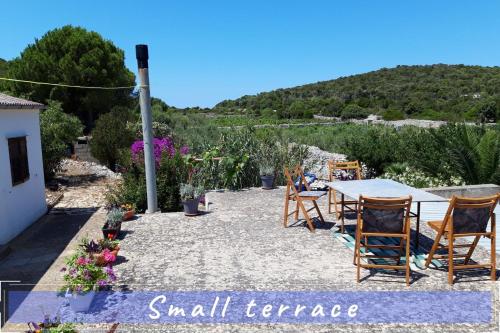 a patio with a table and chairs and a mountain at Near the sea vacation home Parja in Vis