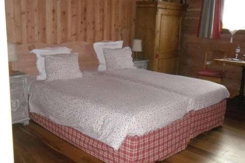 a bedroom with a bed with a white blanket and pillows at la heid d'ehan in Aywaille