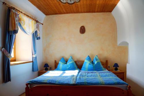 a bedroom with a blue bed with blue pillows at Ferienhaus Haring in Kitzeck im Sausal