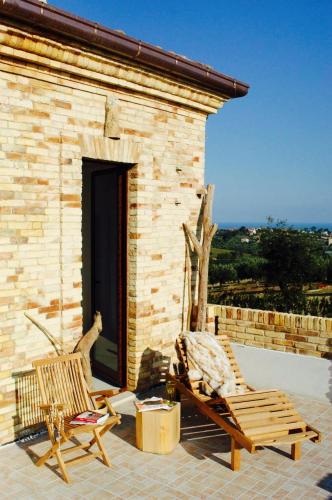 two chairs sitting on the patio of a house at Casa De Campo in Mosciano SantʼAngelo