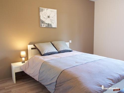 a bedroom with a bed and a table with a lamp at Gite Les Gobelins in Paimpont