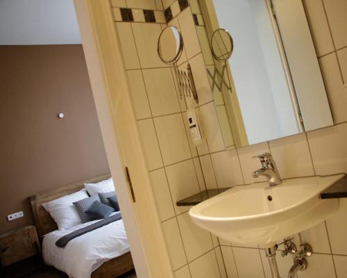 a bathroom with a sink and a bed at Z&B Hotel in Trier