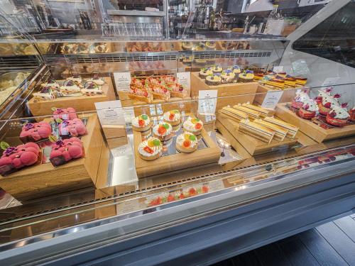 a display case in a bakery with many different pastries at Platan Udvarhaz in Tata