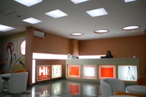 a woman standing at a counter in a waiting room at Hotel Indiana in Pinto