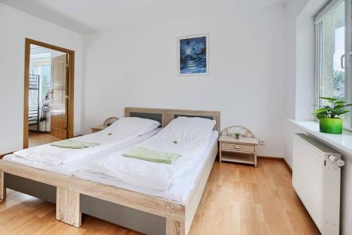 1 dormitorio con 1 cama grande con sábanas blancas en Happiness House Balcony & Nice Garden, en Gdansk