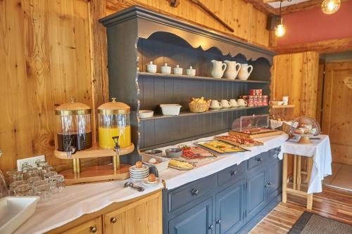 a kitchen with blue cabinets and shelves with food at Sportpension Enzian in Saalbach Hinterglemm