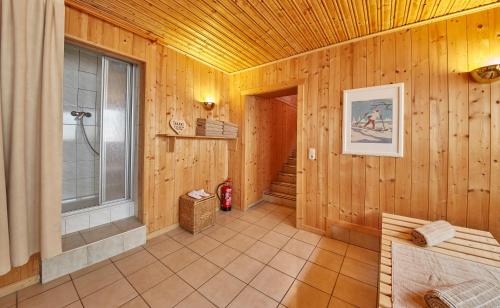 a bathroom with wooden walls and a window and a shower at Sportpension Enzian in Saalbach Hinterglemm
