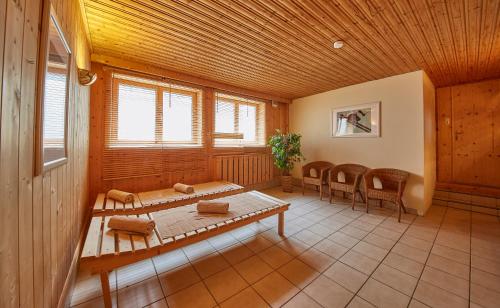 a room with a wooden ceiling and a table and chairs at Sportpension Enzian in Saalbach Hinterglemm