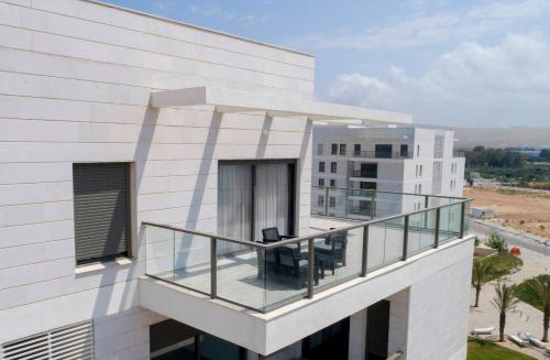 ein Gebäude mit einem Balkon mit zwei Stühlen darauf in der Unterkunft Stylish Penthouse Apartment Close to Akhziv Beach by Sea N' Rent in Naharija