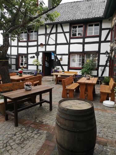 a courtyard with wooden tables and benches and a building at Ferienhof Schmickerath in Simmerath