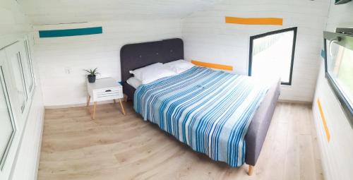 a bedroom with a bed in a small room at Tiny House - Baia de Fier in Baia de Fier