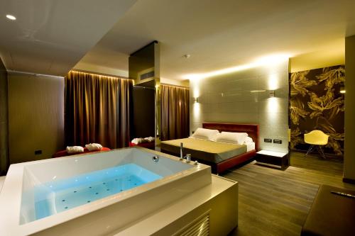 un bagno con vasca e una camera con letto di Viola Mhotel a Grumello del Monte