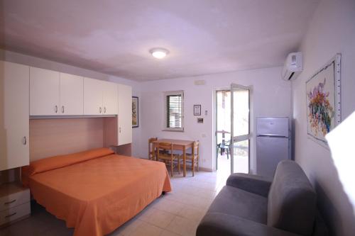 a bedroom with a bed and a couch and a table at La Dimora dei Pescatori in Vieste