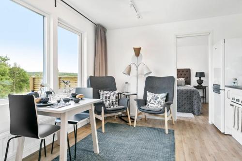 uma sala de estar com uma mesa e cadeiras e um quarto em Hällestrand Village em Strömstad