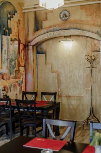 a dining room with tables and chairs and a fireplace at Hotel Fontana in Novi Sad
