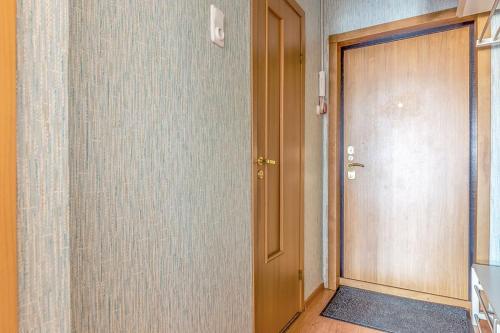 un corridoio con porta in legno e una camera con un piano di Apartment Hanaka Jubileinyi 72 a Reutov