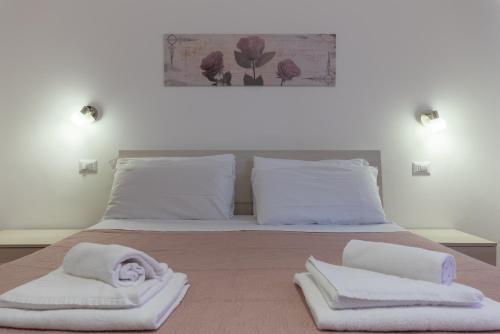 - une chambre avec un lit et des serviettes blanches dans l'établissement Evelina in Trastevere, à Rome