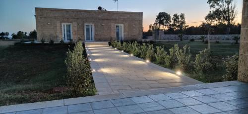 a stone walkway in front of a building with lights at Residenza Case Arse in Torre Lapillo