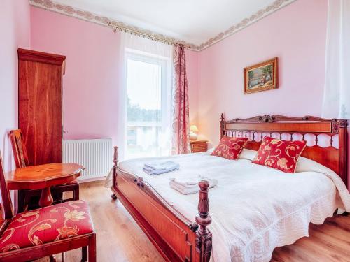- une chambre avec un grand lit et des oreillers rouges dans l'établissement Villa Nicolo, à Władysławowo